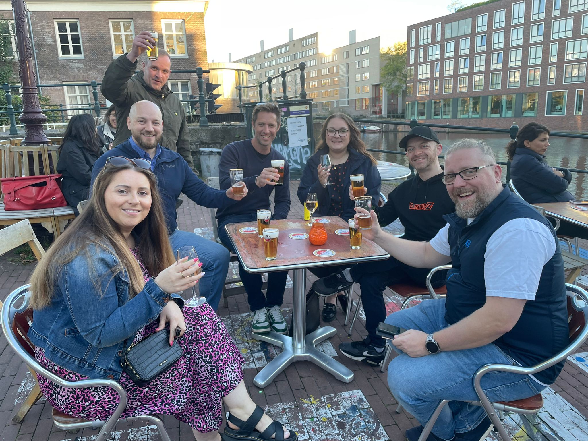 Colleagues saying "cheers" with drinks after a tough day in IBC 2024